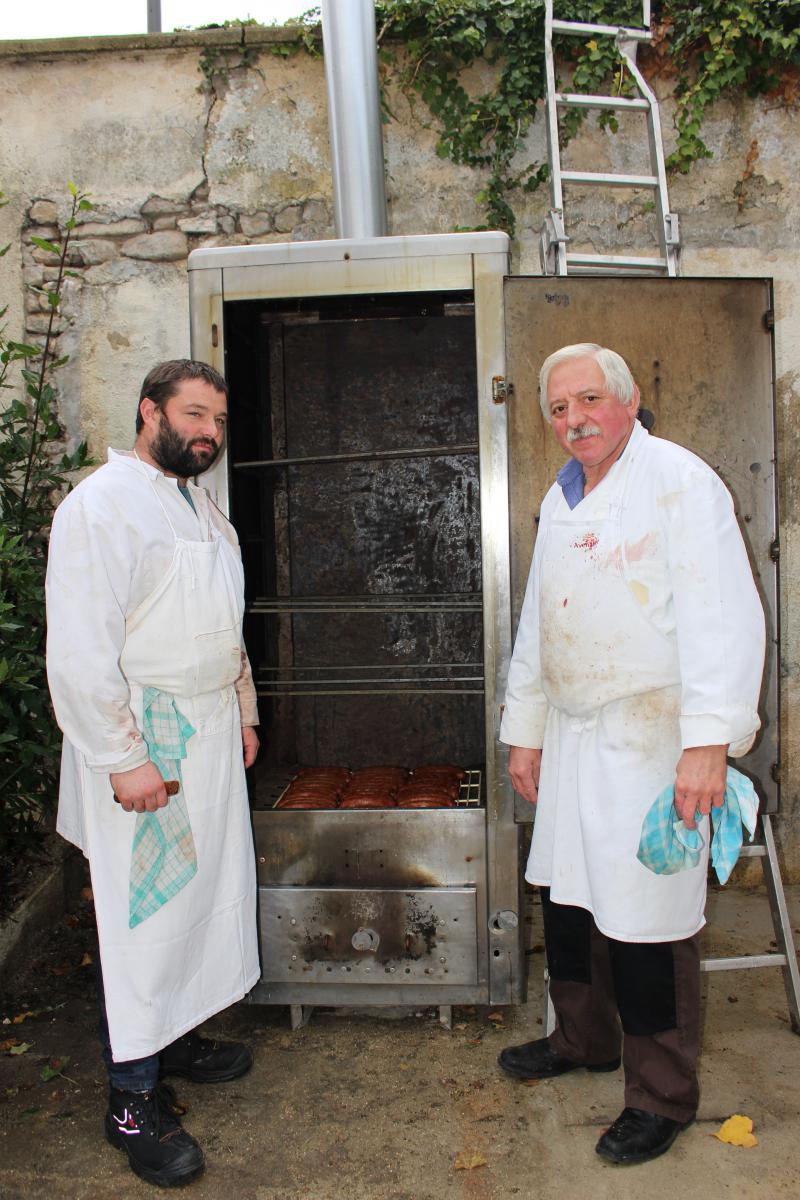 Thomas Boulanger et son boucher Alain Guichaux devant le fumoir d’où vont sortir les saucisses de Toulouse.